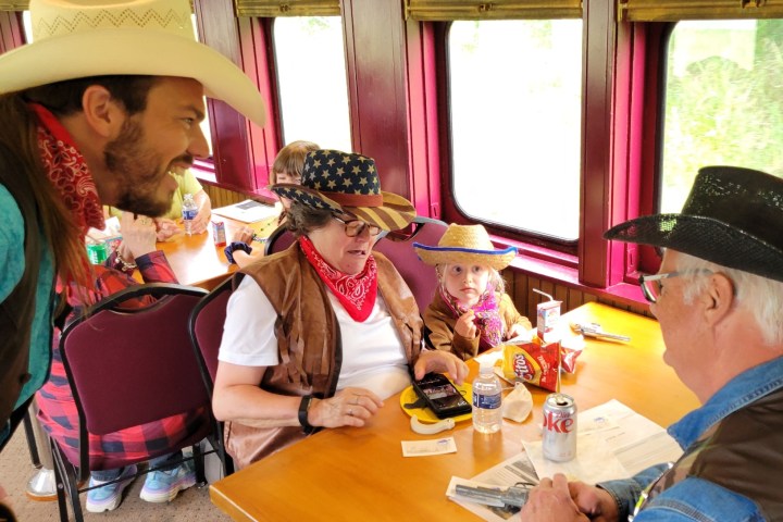 a group of people sitting at a table with a hat